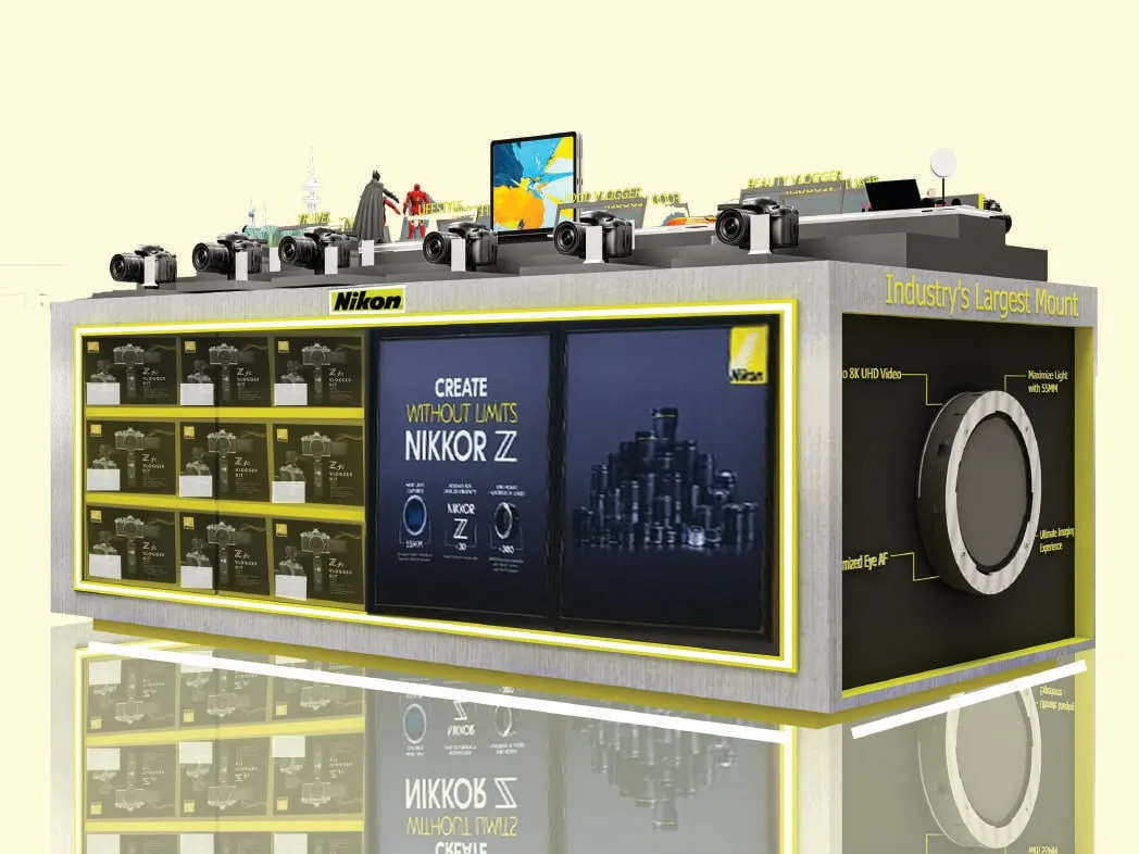 3D render of a Nikon island kiosk with backlit yellow-edged display shelves, cameras on top and a large lens-mount graphic on the end